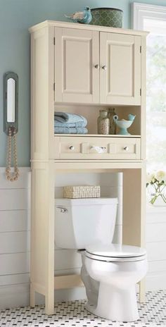 a white toilet sitting next to a wooden cabinet