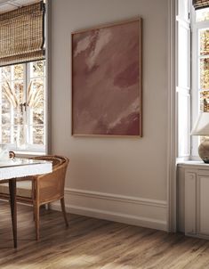 a dining room with a table and chairs in front of a painting on the wall