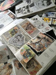 many drawings are spread out on the table