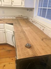 a wooden counter top in a kitchen with white cabinets