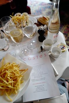 a table topped with glasses and plates filled with food