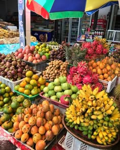 many different types of fruit are on display at the farmers market, including bananas and pineapples