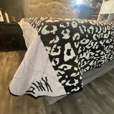 a bed with a black and white leopard print comforter