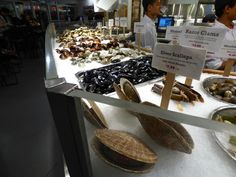 people are standing in front of a buffet table with food on it, including oysters and other foods