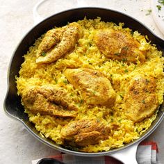 a pan filled with chicken and rice on top of a table