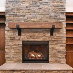 a stone fireplace with shelves and bookshelves in the background