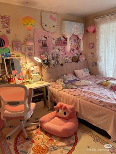 a bedroom with hello kitty decorations on the walls and bed in the middle, desk area next to it