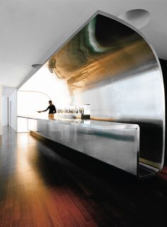 a person sitting at a counter in a room with wood floors and white walls on the wall