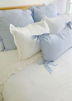 a bed with blue and white striped pillows