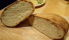 a loaf of bread sitting on top of a wooden cutting board next to a plate