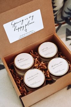 four candles in a brown box on a carpeted floor with a sign that says spring is my happy place