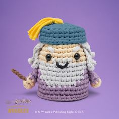 a crocheted doll with a hat and cane in front of a purple background