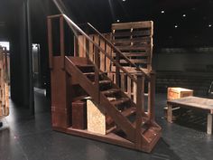 a set of stairs made out of pallets and wooden crates in a theatre setting