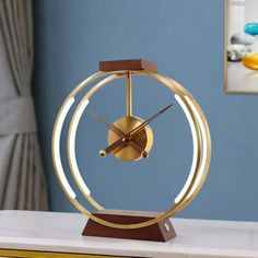 a gold clock sitting on top of a white table next to a blue wall in a living room