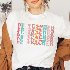 a woman wearing a t - shirt with the words teacher on it in multicolored letters