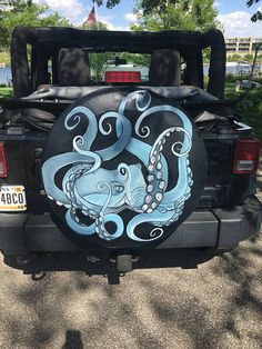 an octopus painted on the back of a black truck with blue and white inks