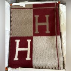 a red and white blanket with the letter h on it