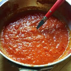 a red sauce being stirred in a pan