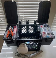 an assortment of tools and supplies are placed in the back of a black case on a white table