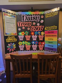 a table with chairs and a sign that says daisy troop