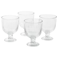 four clear goblets sitting next to each other