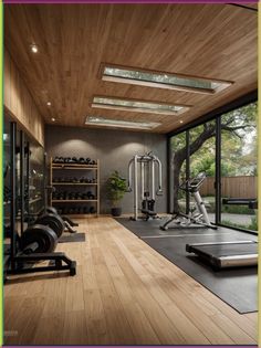 an exercise room with treadmills, machines and yoga mats on the wooden floor