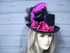 Black costume style hard felt black top hat with black and dark pink ostrich feathers with dark pink roses and black tulle bustle and train. This hat is 22.5" for the inside circumference. PLEASE MEASURE YOU HEAD TO MAKE SURE THIS HAT WILL FIT YOU. I do not take returns and all sales are final. I include a peel and stick hat sizer incase you need it to make the hat smaller. I cannot make the inside larger. Please keep that in mind. This top hat would be perfect for any outfit from Halloween, Kentucky Derby, Wedding anywhere you need a fancy top hat. Roses are from AESilkFlorals here on etsy if you would like to check her shop out. She has beautiful florals. All sales are final! Please keep that in mind when purchasing. Check out my other hats and fascinators.  https://www.etsy.com/shop/MsP Tulle Bustle, Horse Race Hats, Pink Ostrich Feathers, Dark Pink Roses, Doll Hats, Horse Races, Black Top Hat, Mini Top Hat, Black Costume