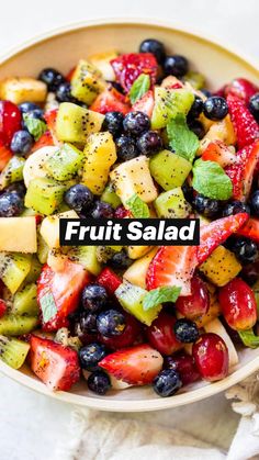 a bowl filled with fruit salad on top of a table