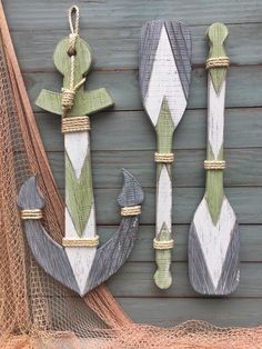 two wooden spoons and an anchor hanging on a wall