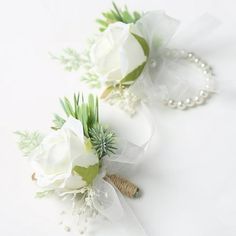 two bridal bouquets with white flowers and greenery on the stems, tied together