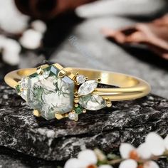 a close up view of a ring on a rock with flowers in the foreground