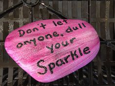 a pink painted rock that says don't let anyone dull, your sparkle