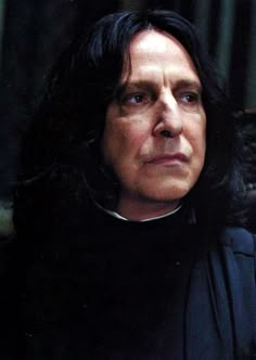 a man with long black hair wearing a priest's outfit and looking off into the distance