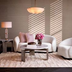 a living room with two white couches and a round coffee table in the center