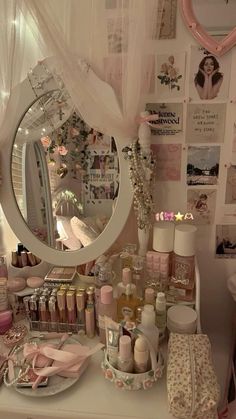 a vanity with lots of items on it and a large round mirror over the top