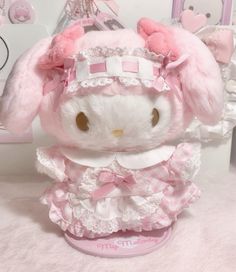 a white stuffed animal wearing a pink dress