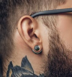 a close up of a man's ear and nose piercing