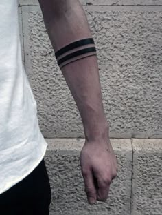 a person with a wrist tattoo on their left arm and one hand holding the other