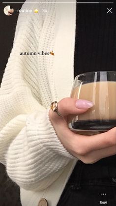 a woman holding a glass of coffee in her hand with the caption autumn vibes