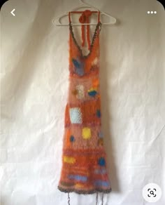 an orange dress hanging on a white wall