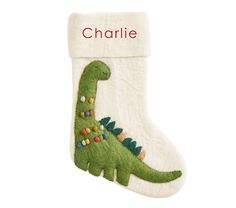 a christmas stocking with a green dinosaur on it and the word charlie written in red