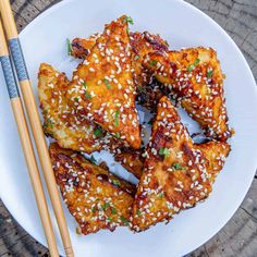 chicken wings with sesame seeds and chopsticks on a plate