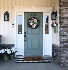 the front door is decorated with wreaths and flowers