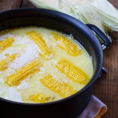 corn on the cob is being cooked in a pot with water and salt inside