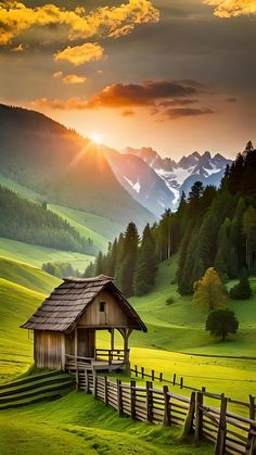 a small cabin in the middle of a green field with mountains and trees behind it