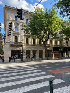 people are walking across the street in front of an old building