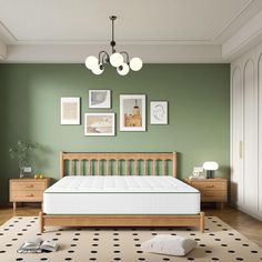 a bed room with a neatly made bed next to a green wall and pictures on the wall