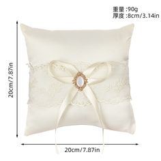 a white pillow with a bow on the side and lace trimmings around it