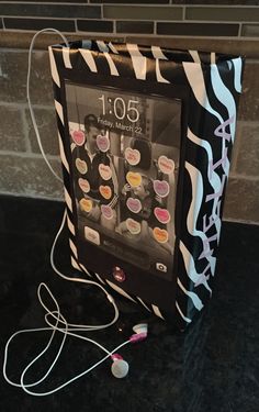 an electronic device with many stickers on it sitting on a counter top next to a brick wall