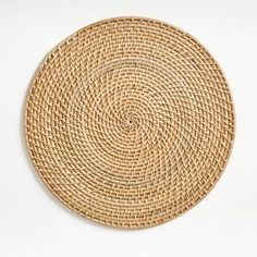 a round woven placemat on a white surface with no one in the photo looking at it